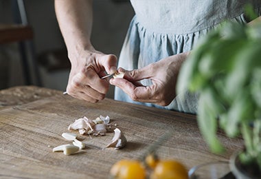 Una persona picando ajos para preparar una merienda para diabéticos