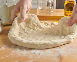 Persona amasando, paso clave al momento de preparar la foccacia italiana 