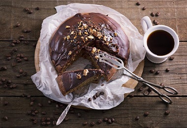 Tarta Sacher acompañada de café negro y servido con unas pinzas de cocina