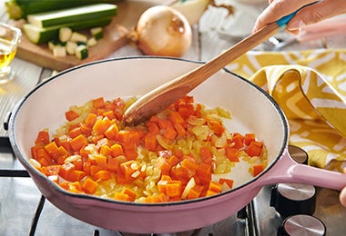 Sartén con cebolla y zanahoria a fuego lento para hacer sofrito