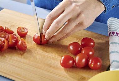 Cortar tomates Cherry a la mitad para confitar tomates