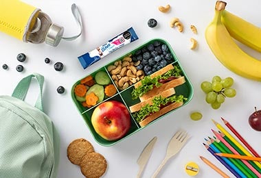 Lonchera saludable con frutas, sándwiches, frutos secos y snack de La Lechera lista para la escuela.