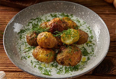 Plato de papas en casco espolvoreadas con cilantro para el Día Internacional de la Papa