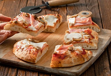 Pizza de prosciutto cortada en porciones