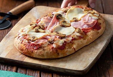 Pizza de prosciutto recién horneada sin cortar