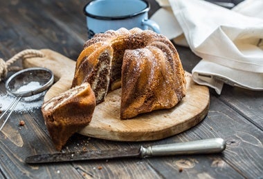 Bundt cake espolvoreado con azúcar glas, acompañado de tamiz de malla fina