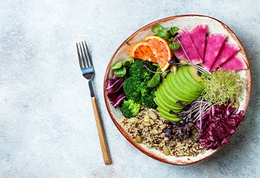 Tazón con ensalada de aguacate colorida con naranja