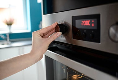 Persona ajustando temperatura del horno para cocinar recetas con papel aluminio