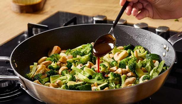 Ensalada de brócoli y hongos aderezada con salsa hoisin en una sartén wok