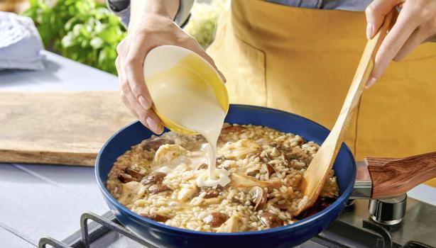 Una persona preparando una receta de cocción lenta con champiñones, crema y arroz.