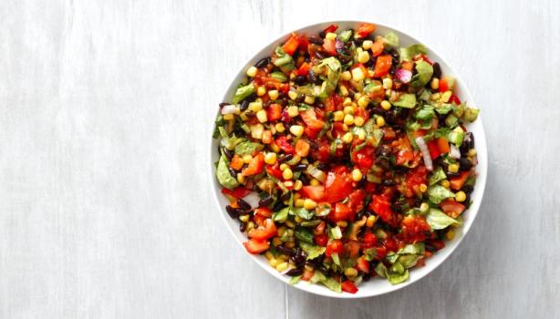 Ensalada marroquí colorida con tomate, maíz, pimiento y hierbas frescas