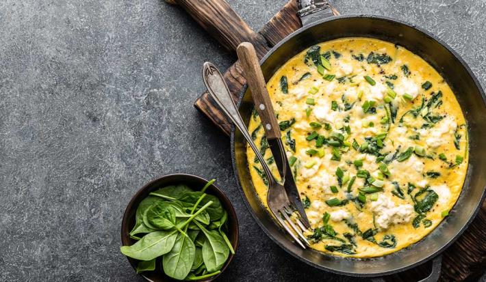 Huevos revueltos y espinaca cremosa sobre arepa